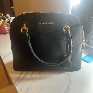 Black Michael Kors purse has a strap inside where can be worn over shoulder.